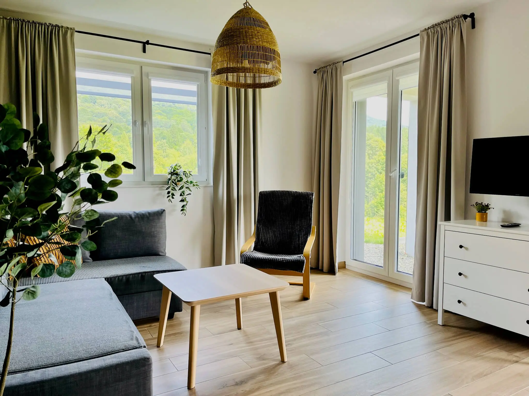 Living room with a comfortable sofa and direct access to the garden in the Hnat apartment